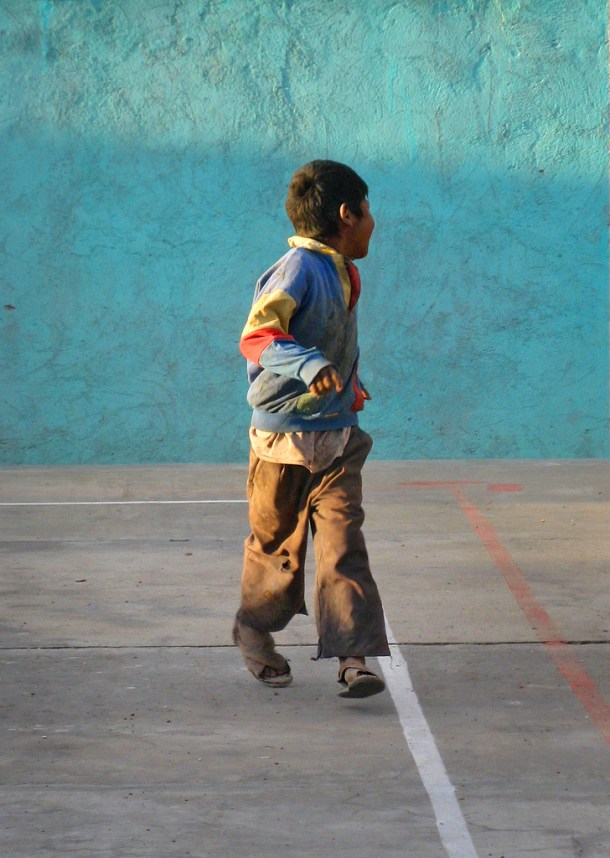 An Aymara boy runs in the sunlight in Uyuni, Bolivia
